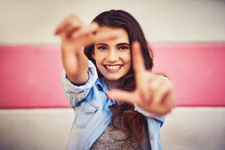 Just picture yourself being happy in your life. Portrait of a beautiful young woman posing against a wall outside.の写真素材