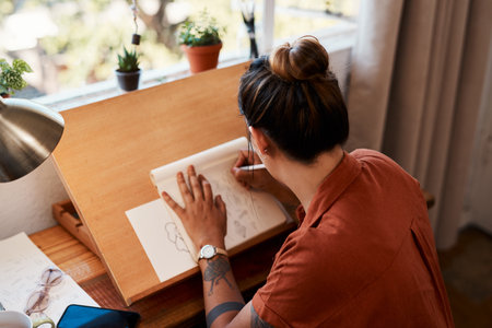 Social media shouldnt be the only place where you express yourself. a young woman sketching at home.の写真素材