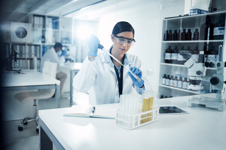 Working as fast and efficient as she can. a young scientist conducting medical research in a laboratory.の写真素材