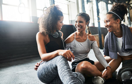 Friends dont let friends workout alone. a group of happy young women taking a break together at the gym.の写真素材