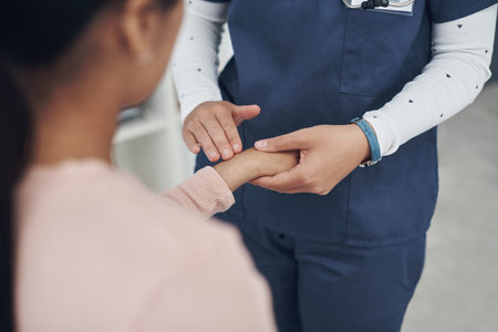 Tell me if that hurts. a unrecognizable doctor checking a patients wrist in an office.の写真素材