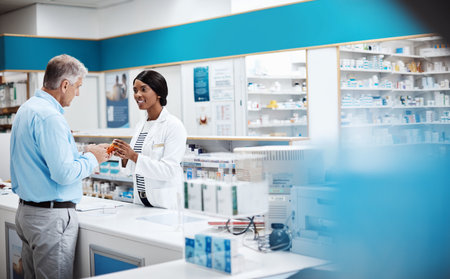 Youll feel better after taking this. a female pharmacist assisting a customer in a drugstore.の写真素材
