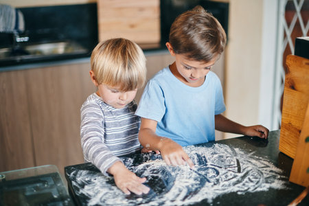 You say baking, we say art. two adorable little boys baking together at home.の写真素材