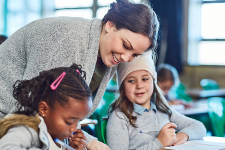 For the love of teaching. elementary school girls getting help from their teacher in the classroom.