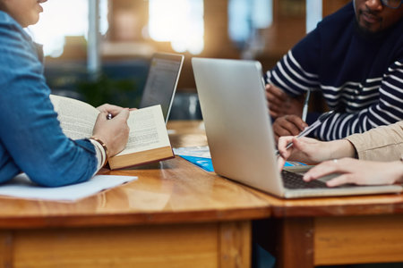 The student life is all about hard work. an unidentifiable group of university students working in the library at campus.の写真素材