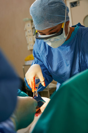 Steady hands and unwavering concentration are key. a team of surgeons performing a surgery in an...