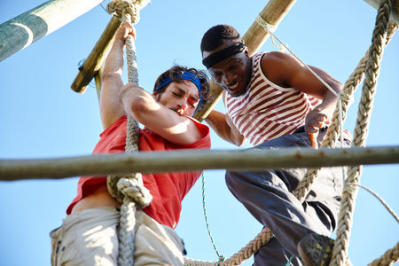The difference between try and triumph is a little umph. two young men going through an obstacle...
