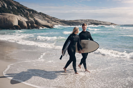 Youre my favourite person to catch waves with. a young couple out surfing together at the beach.の写真素材