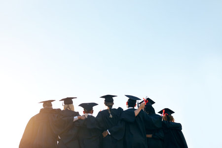 Our journey will be filled with greatness. Rearview shot of a group of university students standing together on graduation day.の写真素材