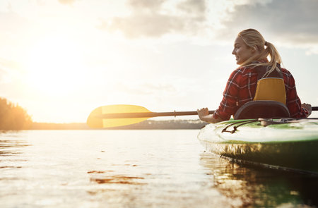 Find your inner peace. a young woman kayaking on a lake.の写真素材