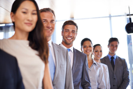 No lack of motivation here. Portrait of a handsome young businessman standing amongst his colleagues.の写真素材