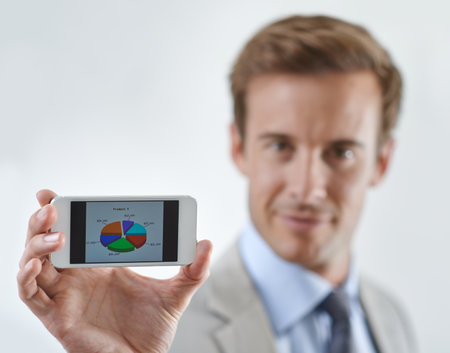 Charting the way to success. A young businessman holding a piechart to the camera.の写真素材