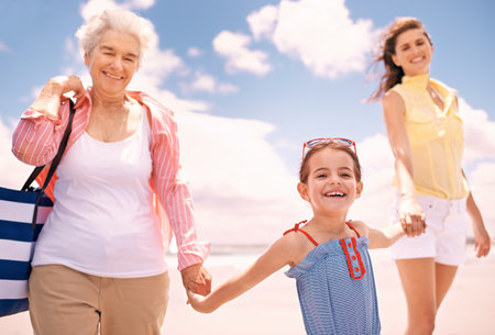 The girls in the family. Portrait of a girl with her mother and grandmother at the beach.の写真素材