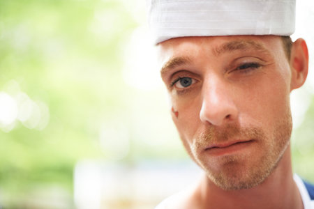 Playful wink. A young man wearing a white hat winking at the camera.の写真素材