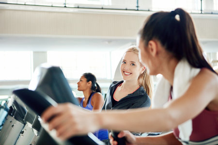 Wanna race. attractive young women working out on treadmills at the gym.の写真素材