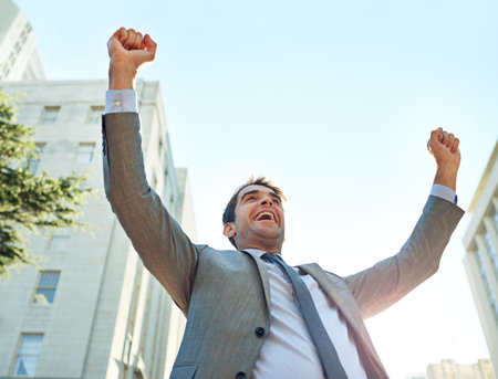 He landed another big deal. a businessman celebrating a success in an urban setting.