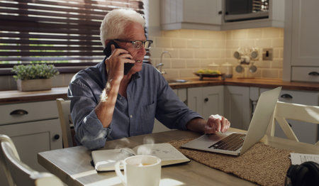 Ill have to follow up on that. a senior man sitting alone in the kitchen and using technology to...
