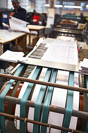 Checking the printing run on the go. Detail shot of the workings of a printing factory.の写真素材