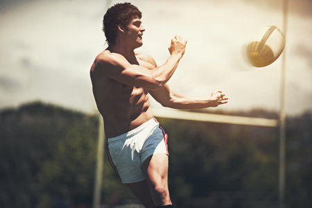 Shirts vs. Skins. a shirtless rugby player executing a pass during a game.の写真素材