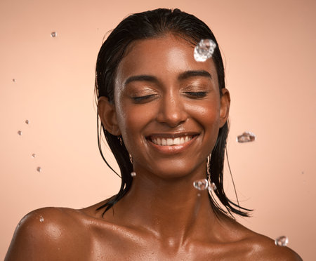 Im an ocean in your bedroom. a young attractive woman doing her daily skincare routine against a brown background.の写真素材