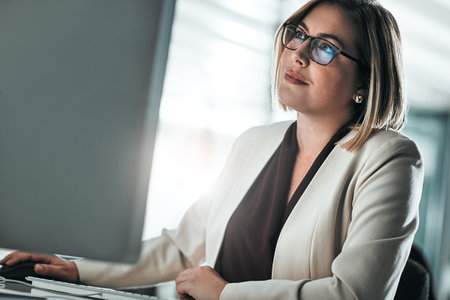 Even the impossible is possible with technology. a businesswoman sitting at her desk.の写真素材