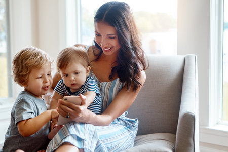 These are pics of when you were a tiny baby. a mother showing her tow little sons something on a...