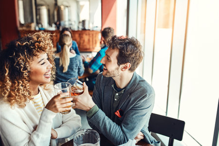 Heres to me being the luckiest man to have you. a young couple having drinks in a bar with people blurred in the background.の写真素材