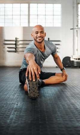 The most important step. a young man stretching his legs before a workout.