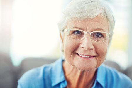 Im lovin retirement. Cropped portrait of a senior woman sitting on her sofa at home.