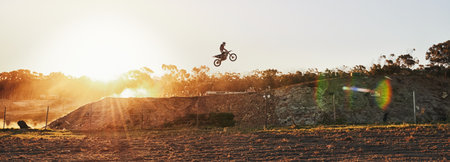 Going over every jump as if its the last. a motocross rider going over a jump during a race.の写真素材