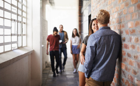 Casual conversation before the next lecture. students conversing in a hallway.