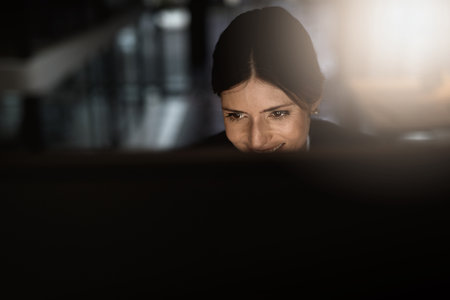 Dreams work when you do. a young businesswoman working online during a late night in a modern office.の写真素材