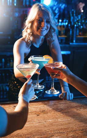 The party has begun. young women drinking cocktails in a nightclub.の写真素材
