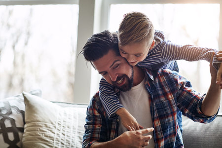 Give them love without condition. a father and his little son bonding together at home.の写真素材