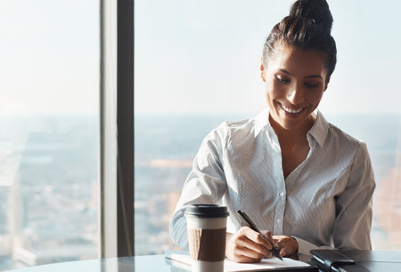 She never lets her paperwork pile up. a young businesswoman working in an office.の写真素材