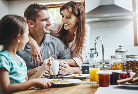 Nothing compares to the love and joy of family. a family having breakfast together at home.の写真素材