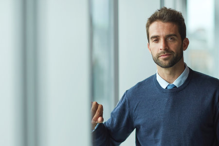 Everything you need to succeed is within you. Cropped portrait of a handsome young businessman standing indoors alone during the day.の写真素材