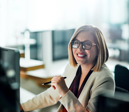 Are you going the extra mile to achieve your goals. a businesswoman sitting at her desk.の写真素材