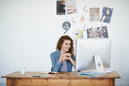 The design looks perfect. a young woman working at her computer in an office.の写真素材