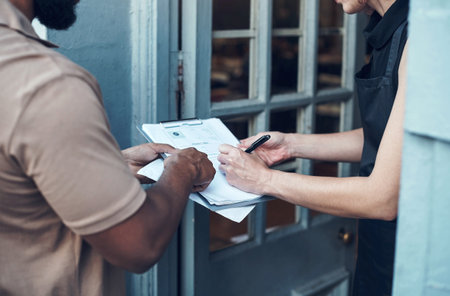 I just need your signature please. an unrecognisable hairdresser signing for a delivery from the courier at her salon.の写真素材