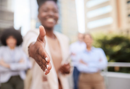 Shall we shake on it. an unrecognisable businesswoman standing with her hand outstretched for a handshake while her colleagues stand behind her.の写真素材