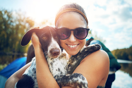Were having so much fun away from the city. a young woman out camping with her dog.の写真素材