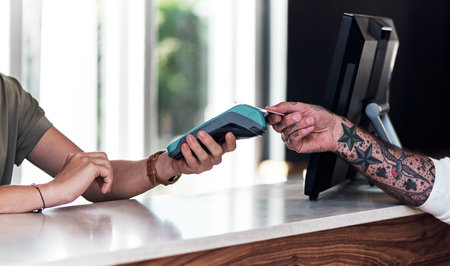 Its as easy as that. an unrecognizable hairdresser using a credit card machine to action a payment inside a salon.の写真素材