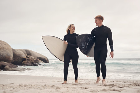 We get a little closer with every surf session. a young couple out at the beach with their surfboards.の写真素材