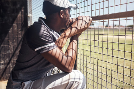 To win the game youve got to understand your opponent. a young man watching a game of baseball from behind the fence.の写真素材
