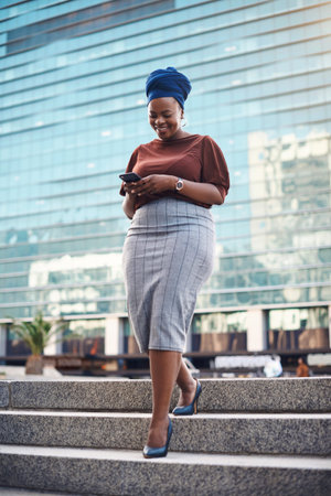 Black woman, phone and city walking of a happy employee with smile and social network app. African...