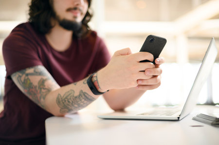 Modern times demands one to stay connected. Closeup shot of an unrecognisable businessman using a cellphone in an office.の写真素材