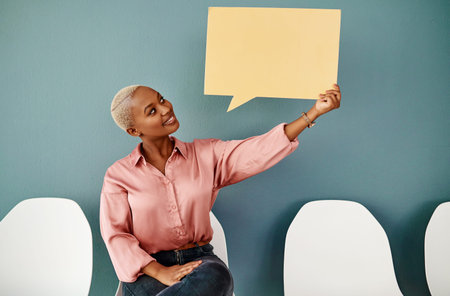 This conversation is getting exciting. Studio shot of an attractive young businesswoman holding up a...