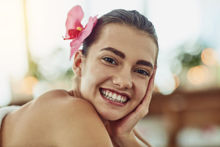 Nothing inspires happiness like a day of beauty. Portrait of an attractive young woman getting pampered at a beauty spa.の写真素材
