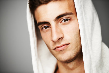 The picture of cool. Close up portrait of a good looking male with a hoodie on.の写真素材